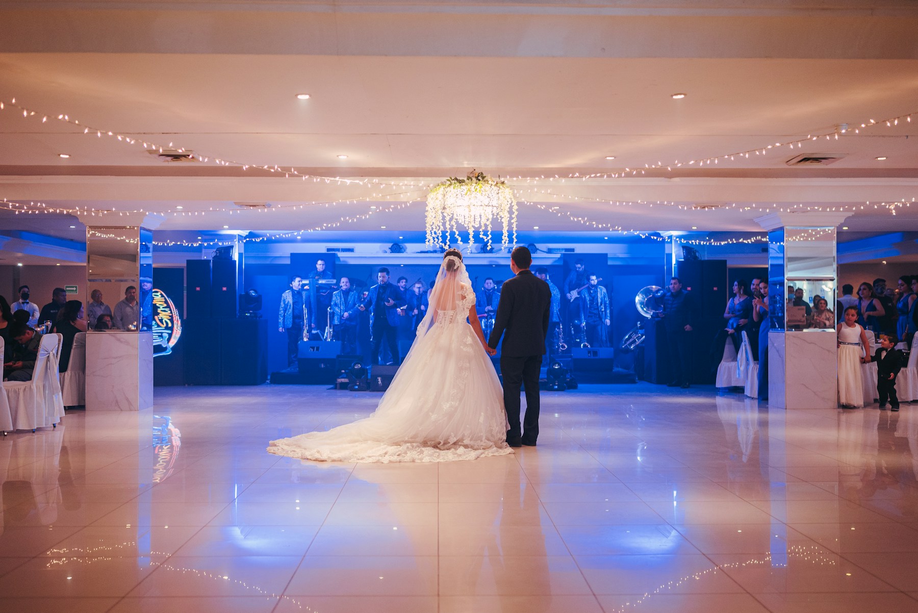 A couple dancing together under warm wedding lights